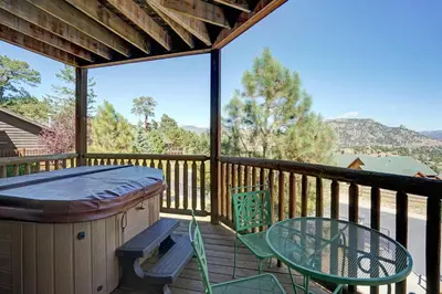 a patio with a table and chairs on a deck at Mount Meeker 26B Condo in Estes Park