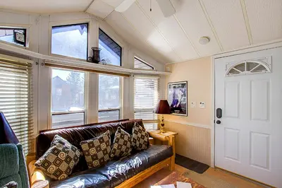 a living room with a leather couch and windows at #84 in Breckenridge