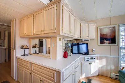 a kitchen with white cabinets and a tv at #84 in Breckenridge