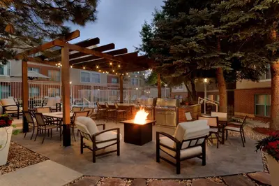 a patio with tables and chairs and a grill at Homewood Suites by Hilton Boulder in Boulder