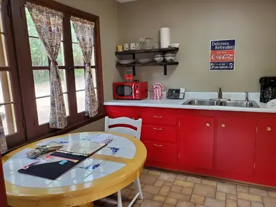 a kitchen with red cabinets and a table and a sink at Swiftcurrent Lodge in Estes Park