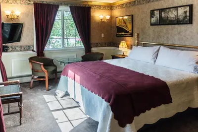 a hotel room with a bed and a tv at Frisco Lodge in Frisco