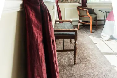 a room with a chair and a curtain at Frisco Lodge in Frisco
