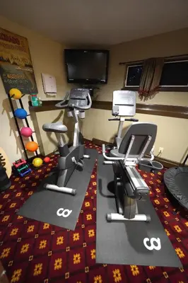 a room with several exercise bikes and a television at Frisco Inn on Galena in Frisco