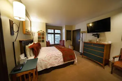 a bedroom with a bed and a desk and a television at Frisco Inn on Galena in Frisco