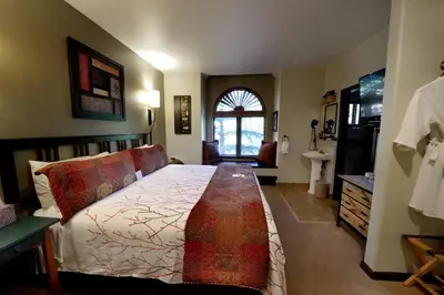 a bedroom with a bed and a sink and a window at Frisco Inn on Galena in Frisco