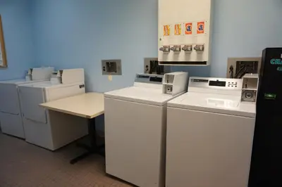 a laundry room with white appliances and a table at The Vintage Hotel in Winter Park