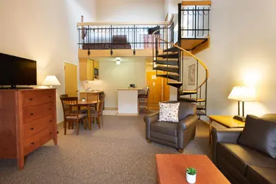 a living room with a couch and a spiral staircase at The Vintage Hotel in Winter Park