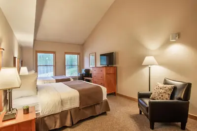 a large bedroom with a bed and a chair at The Vintage Hotel in Winter Park