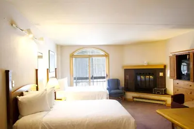a hotel room with two beds and a television at The Vintage Hotel in Winter Park