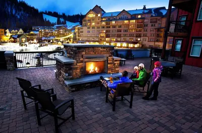 a group of people sitting at tables in front of a fireplace at Fraser Crossing and Founders Pointe in Winter Park