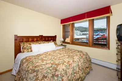 a bedroom with a large bed and a window at Zephyr Mountain Lodge in Winter Park