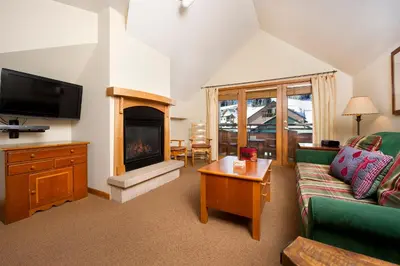 a living room with a couch and a fireplace at Zephyr Mountain Lodge in Winter Park