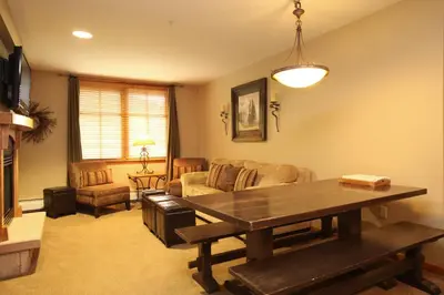 a living room with a table and a couch at Zephyr Mountain Lodge in Winter Park