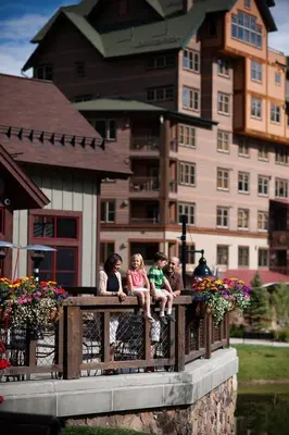 a group of children sitting on a wooden fence at Zephyr Mountain Lodge in Winter Park