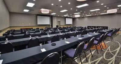 a conference room with long tables and chairs in it at Embassy Suites by Hilton Denver Central Park in Denver