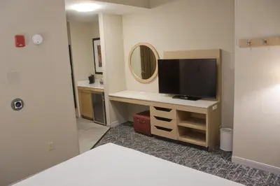 a room with a television on a desk with a mirror at Hampton Inn & Suites Denver-Speer Boulevard in Denver