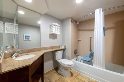 a bathroom with a toilet and a sink and a tub at Hampton Inn Denver-International Airport in Denver