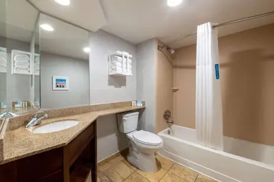 a bathroom with a toilet and a sink and a tub at Hampton Inn Denver-International Airport in Denver