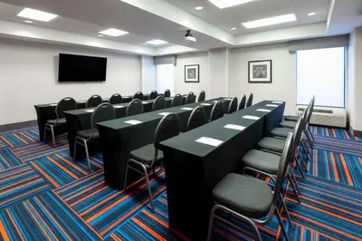 a conference room with black tables and chairs and a flat screen tv at Hampton Inn Denver-International Airport in Denver