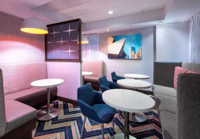 a waiting room with tables and chairs at Hampton Inn Denver-International Airport in Denver
