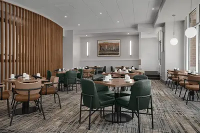 a rendering of a restaurant with tables and chairs at Hilton Garden Inn Denver Downtown in Denver