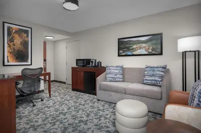 a living room with a couch and a desk at Hilton Garden Inn Denver Downtown in Denver
