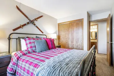 a bedroom with a bed and a cross on the wall at Salt Lick #4812 - Wildernest in Silverthorne