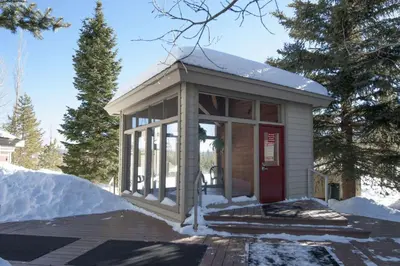 a small building with a red door in the snow at Salt Lick #4812 - Wildernest in Silverthorne