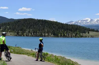 two people riding bikes on a path next to a lake at Timber Ridge #410 - Wildernest in Silverthorne