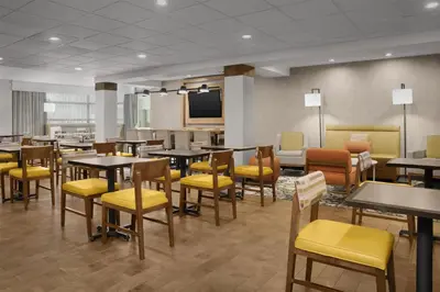 a dining room with tables and yellow chairs at Hampton Inn & Suites Denver Tech Center in Centennial