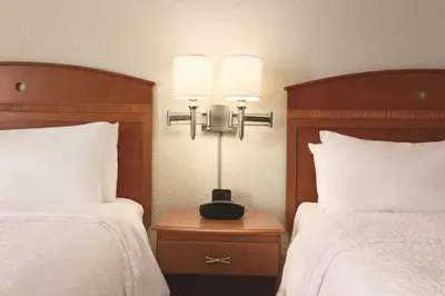 a hotel room with two beds and a lamp on a table at Hampton Inn Denver - Northwest Westminster in Westminster