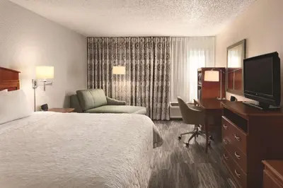 a hotel room with a bed and a desk and a television at Hampton Inn Denver - Northwest Westminster in Westminster