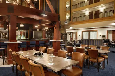 a restaurant with tables and chairs and a bar at Embassy Suites by Hilton Denver International Airport in Denver