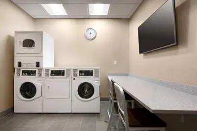 a laundry room with two washing machines and a clock at Courtyard by Marriott Loveland Fort Collins in Loveland