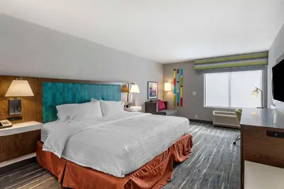 a hotel room with a large bed and a television at Hampton Inn Fort Collins in Fort Collins