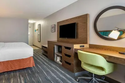 a hotel room with a bed and a desk with a television at Hampton Inn Fort Collins in Fort Collins