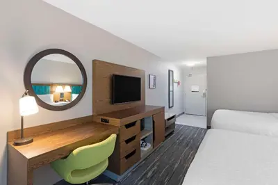 a hotel room with a bed and a mirror at Hampton Inn Fort Collins in Fort Collins