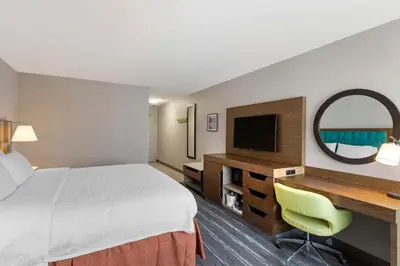 a hotel room with a bed and a desk and a television at Hampton Inn Fort Collins in Fort Collins