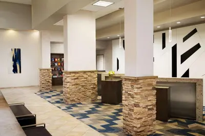 a lobby with white columns and a fireplace at Hilton Fort Collins in Fort Collins