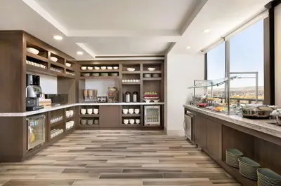 a large kitchen with wooden cabinets and a large window at Hilton Fort Collins in Fort Collins