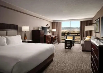 a hotel room with a large bed and a desk at Hilton Fort Collins in Fort Collins
