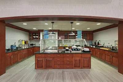 a large kitchen with wooden cabinets and a large counter at Homewood Suites by Hilton Fort Collins in Fort Collins