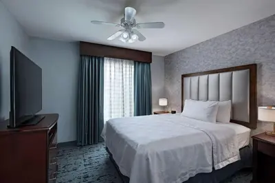 a bedroom with a bed with a ceiling fan and a television at Homewood Suites by Hilton Fort Collins in Fort Collins