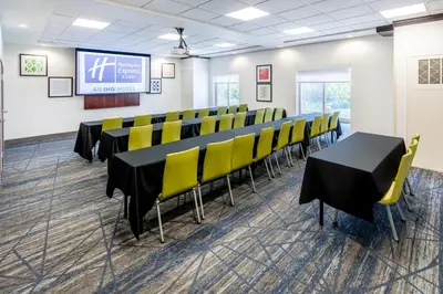 a conference room with black tables and yellow chairs at Holiday Inn Express & Suites Denver North - Thornton by IHG in Thornton