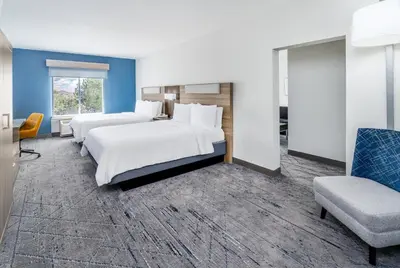 a hotel room with two beds and a chair at Holiday Inn Express & Suites Denver North - Thornton by IHG in Thornton