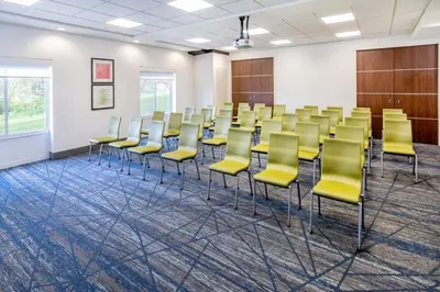 a conference room with yellow chairs and a wall at Holiday Inn Express & Suites Denver North - Thornton by IHG in Thornton