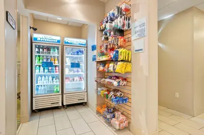 a grocery store aisle with a refrigerator and drinks at Holiday Inn Express & Suites Denver North - Thornton by IHG in Thornton