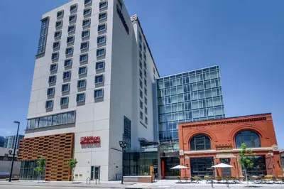 a tall white building with tables in front of it at Hilton Garden Inn Denver Union Station in Denver