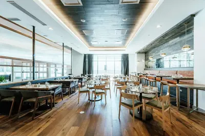 a dining room with tables and chairs and windows at Hilton Garden Inn Denver Union Station in Denver